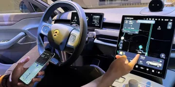 موظف يشرح لممثلي وسائل الإعلام طريقة اتصال نيو فون بسيارة خلال يوم التكنولوجيا الخاص بصانع السيارات الكهربائية الصينية في شنغهاي بالصين يوم 21 سبتمبر أيلول 2023. تصوير: زوي تشانغ - رويترز.
